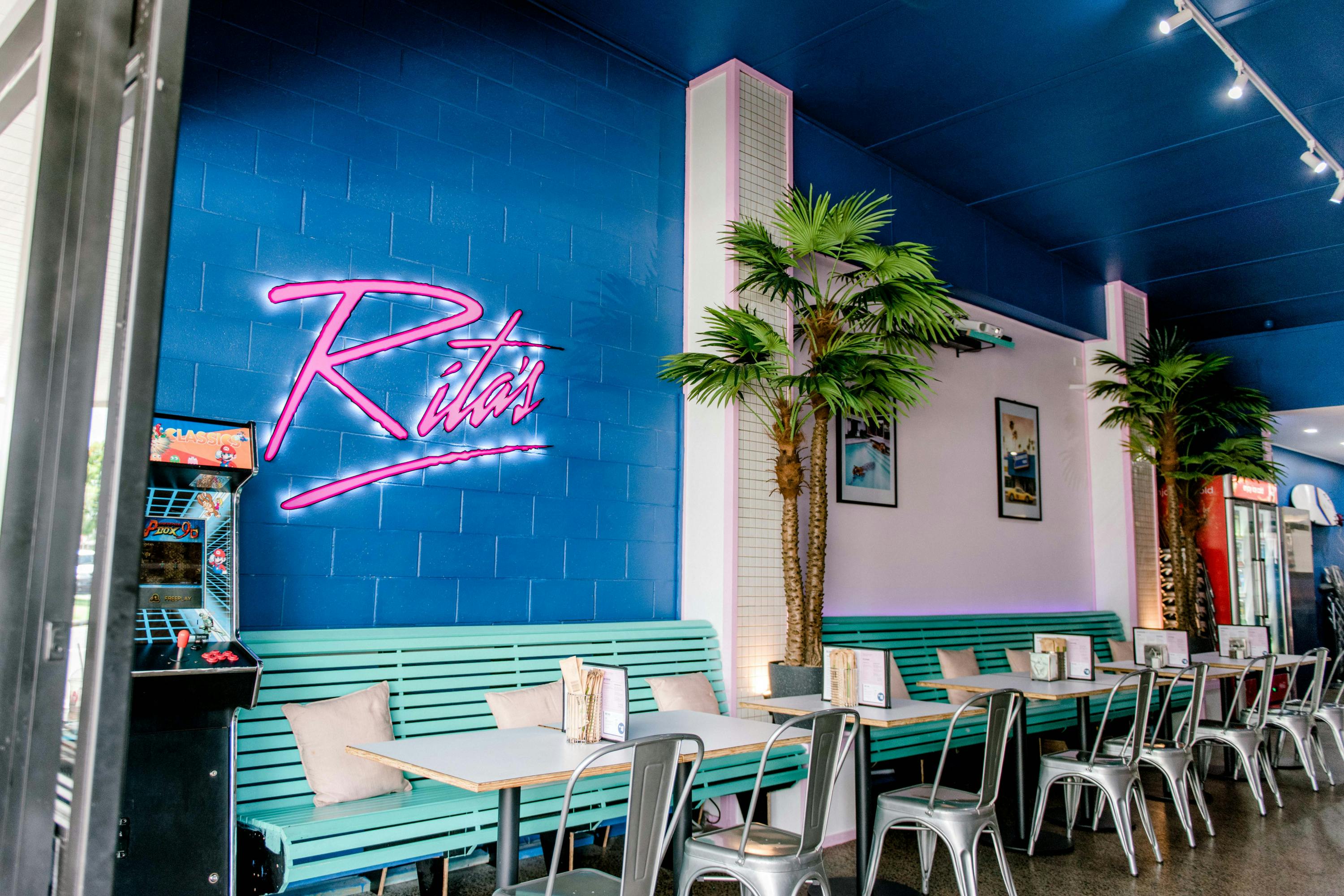 an 80s inspired diner with a pink neon sign that says